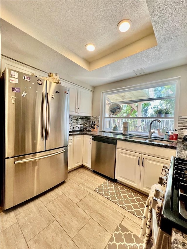 29403 Clear View Ln, Highland, CA 92346 - kitchen featuring appliances with stainless steel finishes, a sink, a textured ceiling, tasteful backsplash, and dark countertops