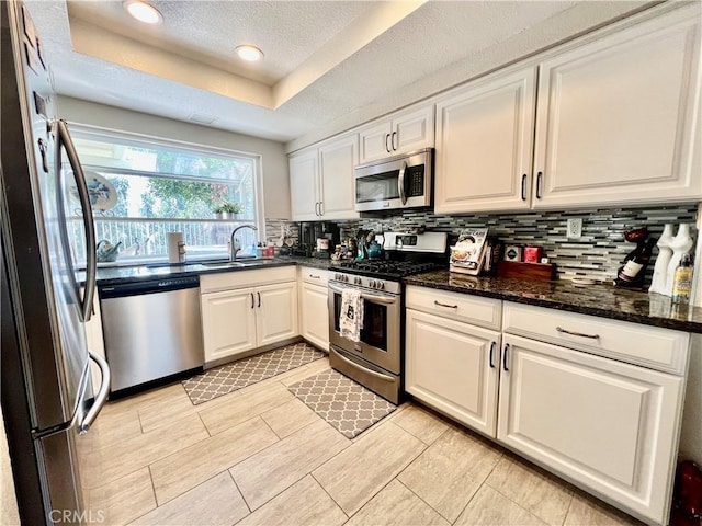 29403 Clear View Ln, Highland, CA 92346 - kitchen featuring appliances with stainless steel finishes, a sink, backsplash, white cabinetry, and a textured ceiling