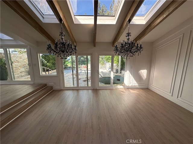 23128 Park Sorrento, Calabasas, CA 91302 - unfurnished sunroom featuring a chandelier, a skylight, a decorative wall, beam ceiling, and wood finished floors
