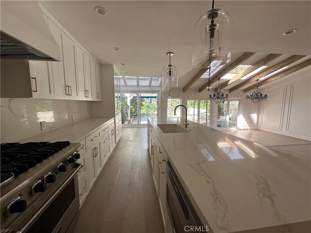 23128 Park Sorrento, Calabasas, CA 91302 - kitchen with high end stove, a sink, custom exhaust hood, white cabinetry, and light stone countertops