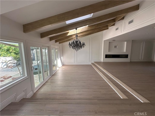 23128 Park Sorrento, Calabasas, CA 91302 - unfurnished living room featuring a skylight, a chandelier, light wood-style flooring, and beam ceiling