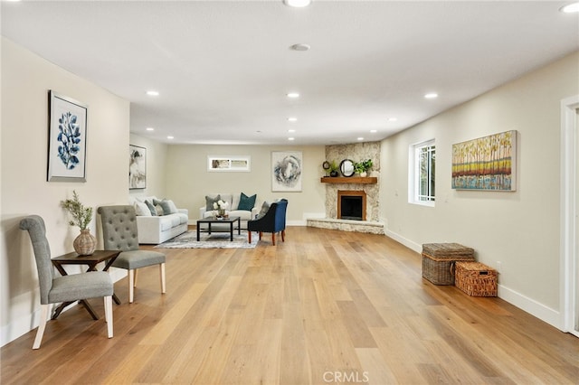 1917 N Quince Way, Upland, CA 91784 - living area featuring light wood-type flooring, a stone fireplace, recessed lighting, and baseboards