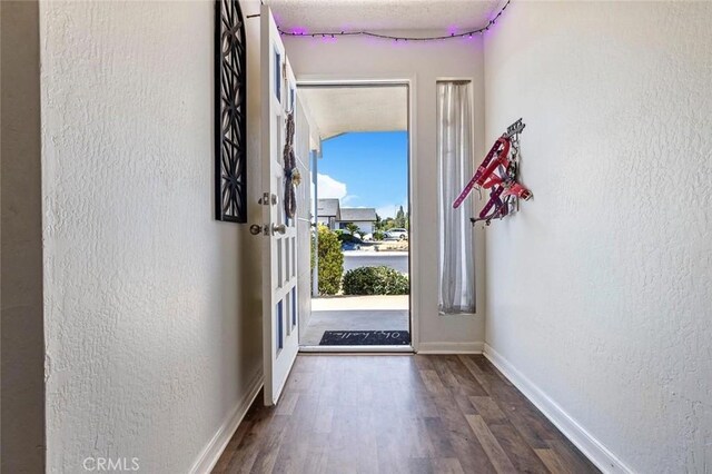 2192 Beverly Ave, Clovis, CA 93611 - doorway to outside featuring a textured wall, wood finished floors, and baseboards