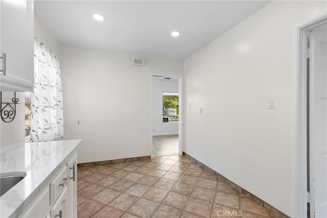 11422 Charlesworth Rd, Santa Fe Springs, CA 90670 - kitchen with baseboards, white cabinets, light countertops, recessed lighting, and light stone finish floors