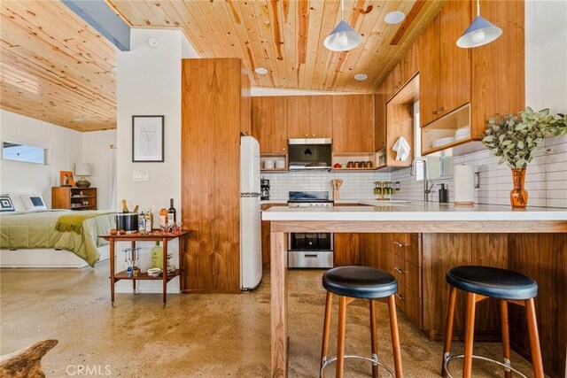 79124 Valle Vista Rd Unit 29, Palms, CA 92277 - kitchen with appliances with stainless steel finishes, wood ceiling, brown cabinetry, a peninsula, and light countertops
