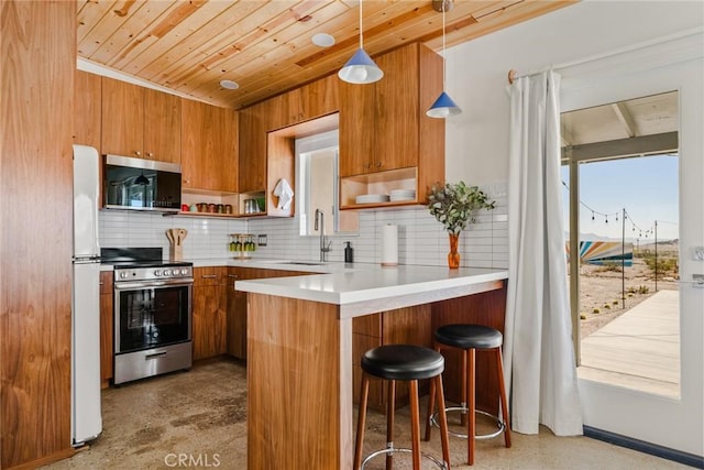 79124 Valle Vista Rd Unit 29, Palms, CA 92277 - kitchen featuring stainless steel appliances, a sink, open shelves, brown cabinets, and backsplash