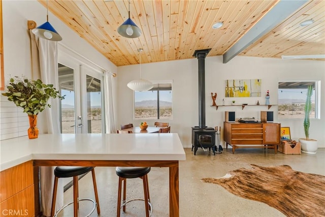 79124 Valle Vista Rd Unit 29, Palms, CA 92277 - dining space featuring a wood stove, wood ceiling, french doors, and finished concrete flooring