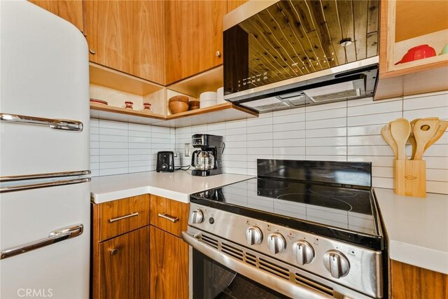 79124 Valle Vista Rd Unit 29, Palms, CA 92277 - kitchen with electric range, tasteful backsplash, light countertops, open shelves, and brown cabinets