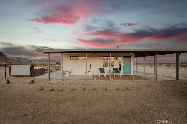 79124 Valle Vista Rd Unit 29, Palms, CA 92277 - back of property at dusk featuring stucco siding and a patio area