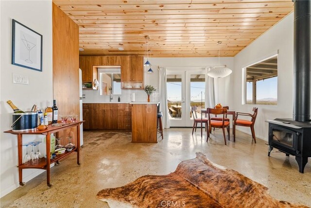 79124 Valle Vista Rd Unit 29, Palms, CA 92277 - kitchen featuring a wood stove, wood ceiling, brown cabinetry, pendant lighting, and light countertops