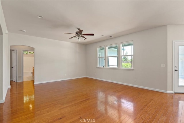 1095 Glenwood Ln, Willows, CA 95988 - unfurnished room featuring a ceiling fan, arched walkways, baseboards, and light wood-style flooring