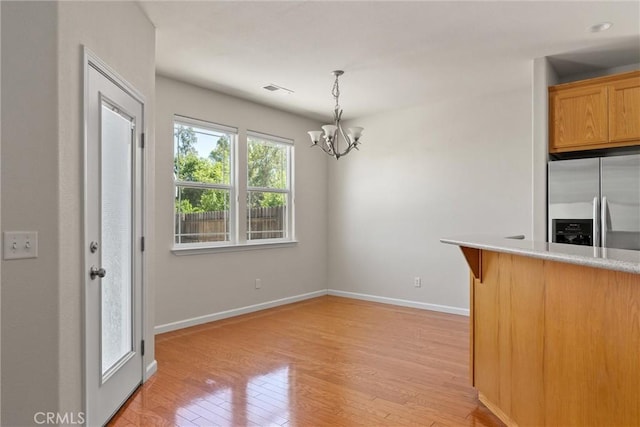 1095 Glenwood Ln, Willows, CA 95988 - kitchen with stainless steel refrigerator with ice dispenser, light wood-type flooring, baseboards, a chandelier, and light countertops