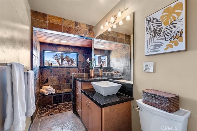 8830 Quail Springs Rd, Joshua Tree, CA 92252 - bathroom featuring toilet, vanity, a tile shower, and stone finish flooring