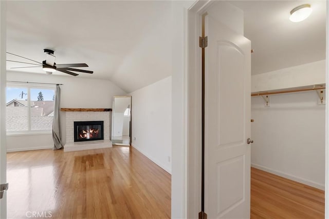 5492 Carousel Cir, Garden Grove, CA 92845 - unfurnished living room with ceiling fan, light wood-style flooring, lofted ceiling, a brick fireplace, and baseboards