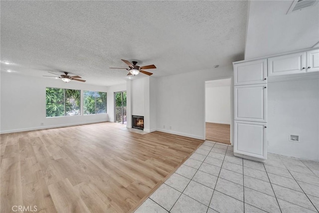 901 Golden Springs Dr Unit D13, Diamond Bar, CA 91765 - unfurnished living room featuring ceiling fan, a textured ceiling, light wood-style floors, a fireplace, and baseboards