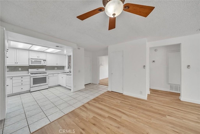 901 Golden Springs Dr Unit D13, Diamond Bar, CA 91765 - kitchen with white appliances, a sink, light wood-style floors, light countertops, and white cabinets