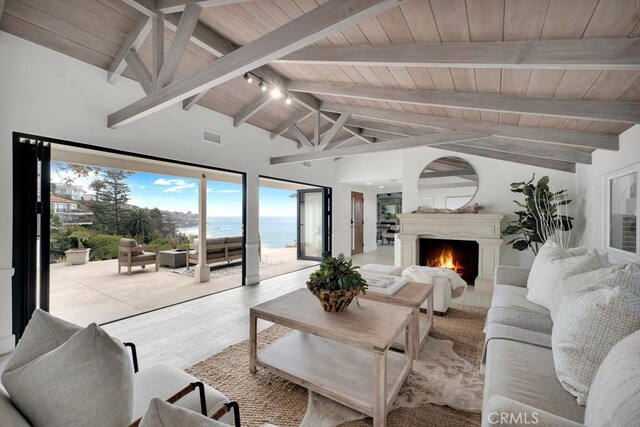 10 Camel Pt, Laguna Beach, CA 92651 - living area featuring wood ceiling with exposed beams, a water view, a warm lit fireplace, wood finished floors, and high vaulted ceiling