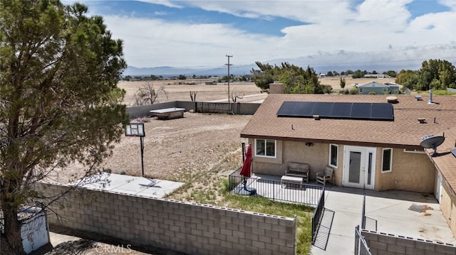 8225 W W Ave E4, Lancaster, CA 93536 - exterior space with a patio area, solar panels, french doors, a fenced backyard, and roof with shingles