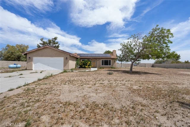 8225 W W Ave E4, Lancaster, CA 93536 - ranch-style home with roof mounted solar panels, a garage, a chimney, concrete driveway, and stucco siding