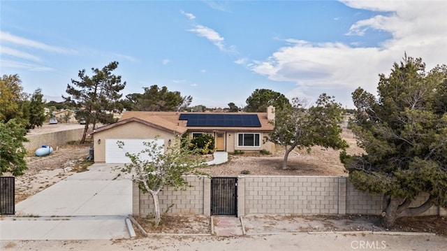 8225 W W Ave E4, Lancaster, CA 93536 - view of front of property featuring a fenced front yard, a gate, concrete driveway, solar panels, and an attached garage