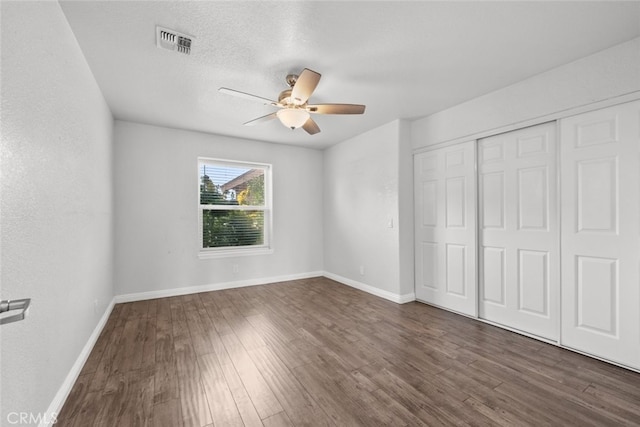 8225 W W Ave E4, Lancaster, CA 93536 - unfurnished bedroom featuring dark wood finished floors, baseboards, a closet, and a ceiling fan