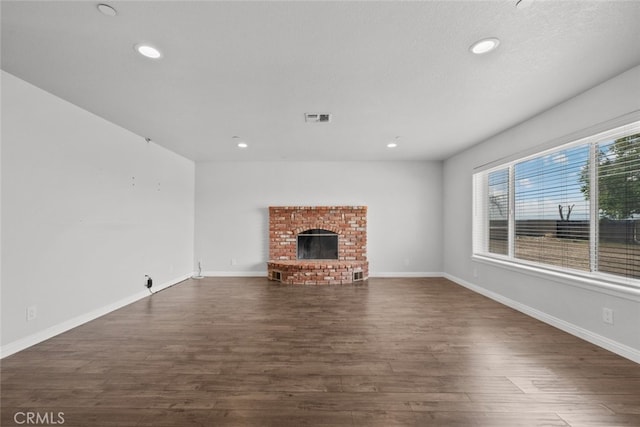 8225 W W Ave E4, Lancaster, CA 93536 - unfurnished living room featuring dark wood finished floors, recessed lighting, a brick fireplace, and baseboards