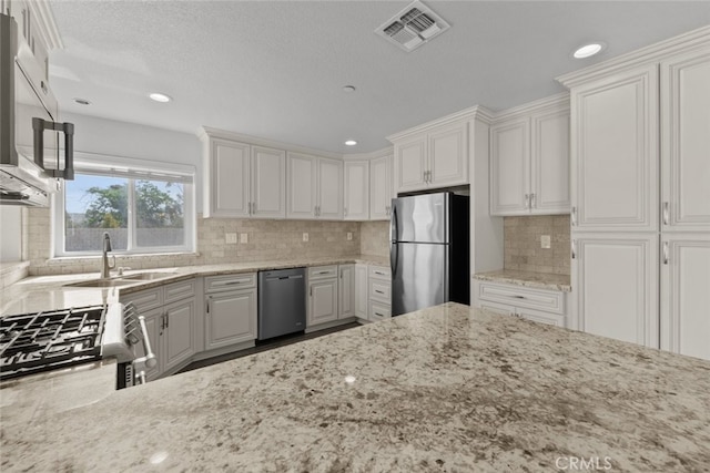 8225 W W Ave E4, Lancaster, CA 93536 - kitchen with appliances with stainless steel finishes, a sink, light stone countertops, recessed lighting, and tasteful backsplash
