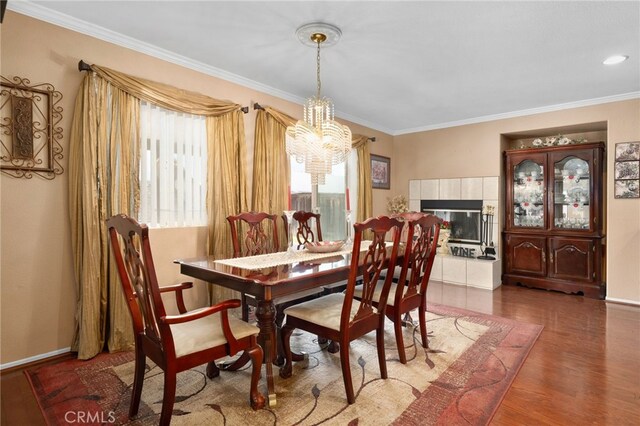 16290 Via Ultimo, Moreno Valley, CA 92551 - dining area with a chandelier, crown molding, wood finished floors, baseboards, and a fireplace
