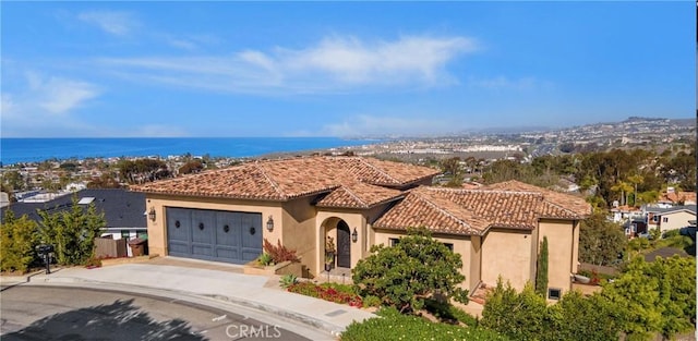 121 Avenida Pizarro, San Clemente, CA 92672 - view of front of property featuring concrete driveway, stucco siding, a garage, a tile roof, and a water view