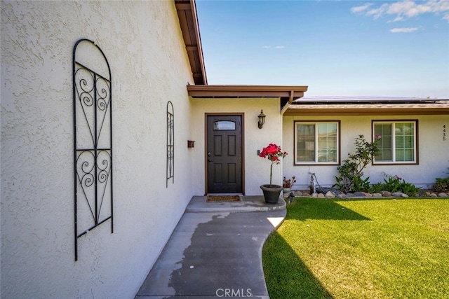 4435 Via Del Prado, Yorba Linda, CA 92886 - doorway to property featuring solar panels, a yard, and stucco siding