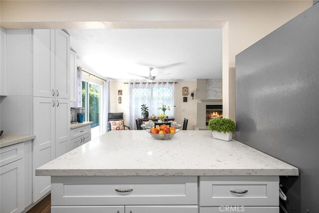 4435 Via Del Prado, Yorba Linda, CA 92886 - kitchen with white cabinets, a fireplace, light stone counters, and open floor plan