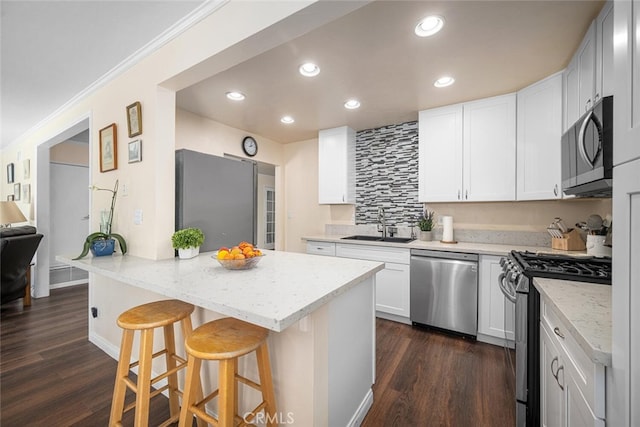 4435 Via Del Prado, Yorba Linda, CA 92886 - kitchen featuring stainless steel appliances, a breakfast bar area, a peninsula, white cabinetry, and dark wood finished floors