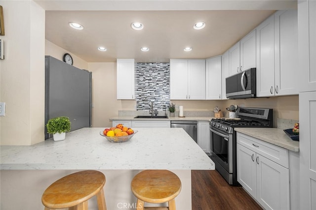 4435 Via Del Prado, Yorba Linda, CA 92886 - kitchen with stainless steel appliances, a kitchen bar, recessed lighting, white cabinets, and dark wood-style flooring