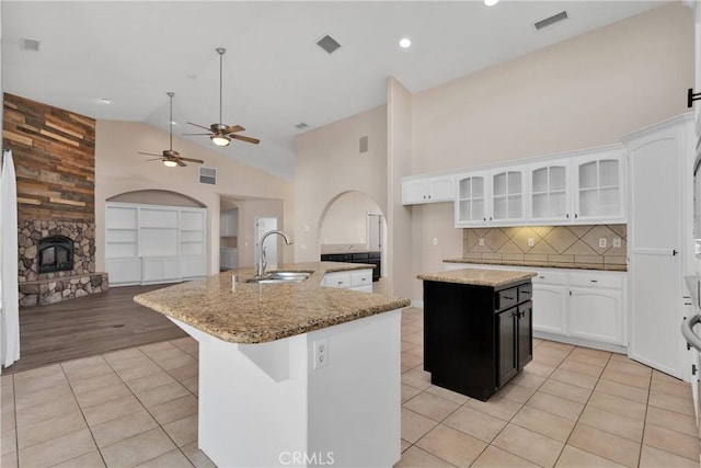 6786 Middleton Ave, Hesperia, CA 92345 - kitchen featuring an island with sink, a fireplace, light tile patterned floors, a ceiling fan, and white cabinetry