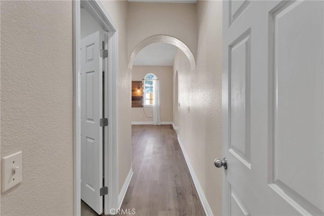 6786 Middleton Ave, Hesperia, CA 92345 - hall featuring arched walkways, a textured wall, and wood finished floors