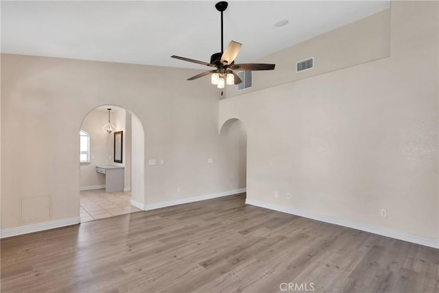 6786 Middleton Ave, Hesperia, CA 92345 - empty room featuring arched walkways, a ceiling fan, and wood finished floors