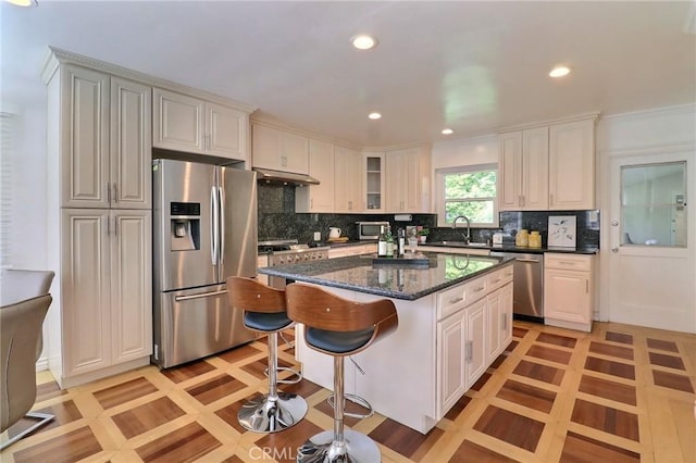 2953 E California Blvd, Pasadena, CA 91107 - kitchen featuring stainless steel appliances, under cabinet range hood, a kitchen island, a breakfast bar, and decorative backsplash