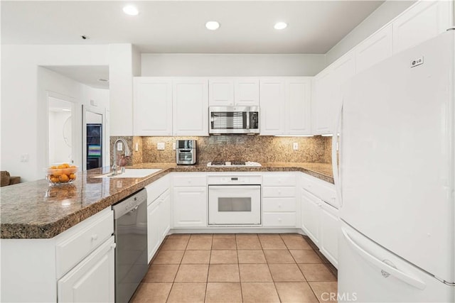 26974 Colonial Ln, Valencia, CA 91355 - kitchen featuring appliances with stainless steel finishes, a sink, a peninsula, white cabinets, and tasteful backsplash