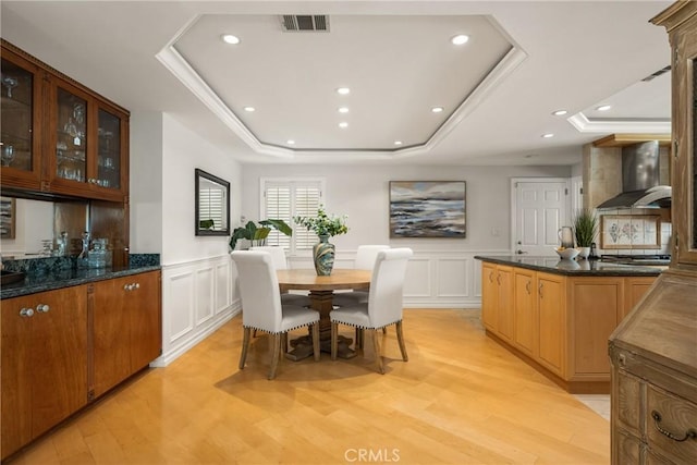 13061 Rosalind Dr, North Tustin, CA 92705 - dining area with a raised ceiling, light wood-type flooring, a decorative wall, recessed lighting, and a wainscoted wall