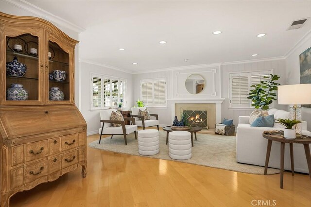 13061 Rosalind Dr, North Tustin, CA 92705 - living area featuring crown molding, light wood-style flooring, recessed lighting, baseboards, and a warm lit fireplace