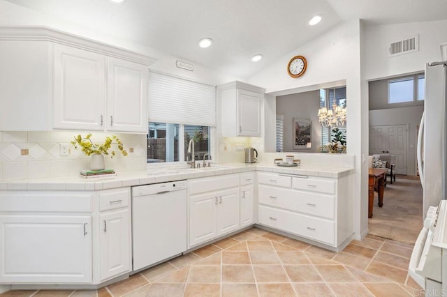 7414 Lantana, Carlsbad, CA 92011 - kitchen with white appliances, tile counters, vaulted ceiling, white cabinets, and backsplash