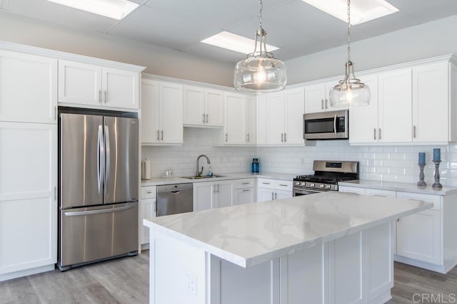 7414 Lantana, Carlsbad, CA 92011 - kitchen with appliances with stainless steel finishes, light wood finished floors, white cabinetry, tasteful backsplash, and light stone countertops