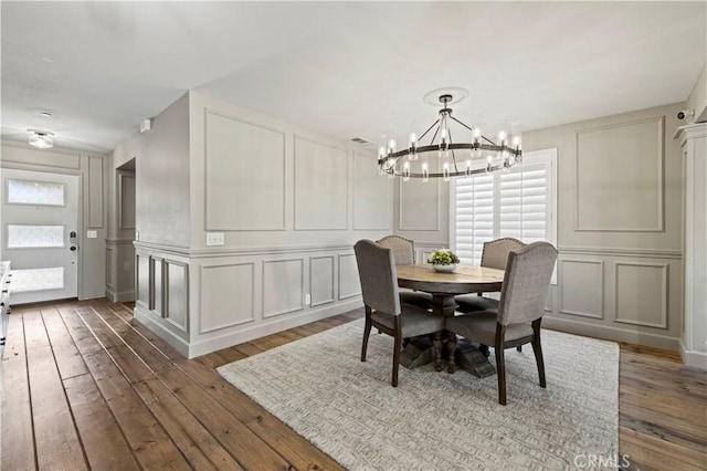 5239 Jade Ct, Lancaster, CA 93536 - dining area with a decorative wall, a chandelier, and hardwood / wood-style flooring