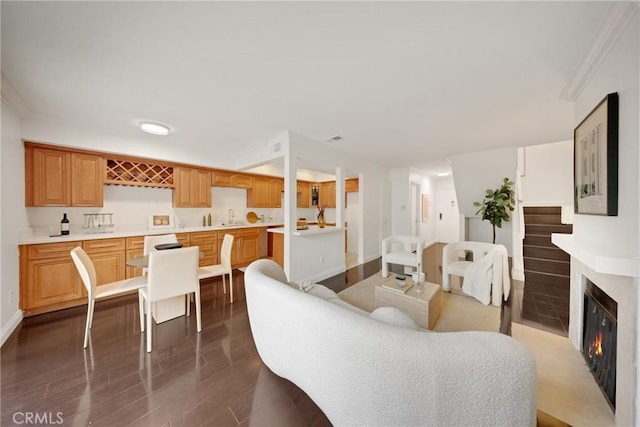 187 S Catalina Ave Unit 4, Pasadena, CA 91106 - living area with dark wood finished floors, a glass covered fireplace, bar, baseboards, and ornamental molding