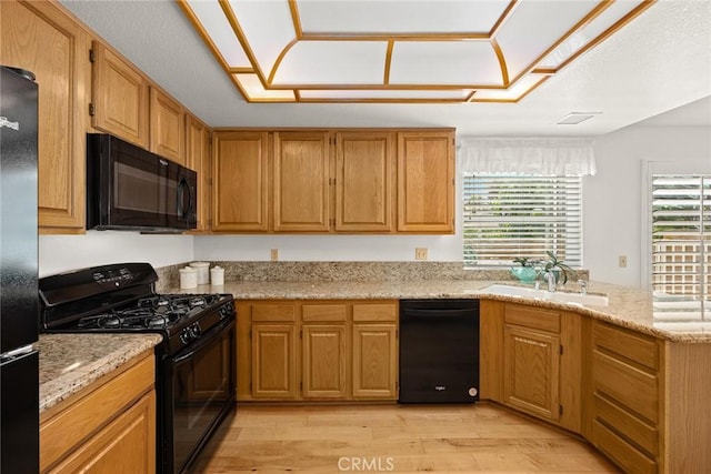 5787 Blackbird Ln, La Verne, CA 91750 - kitchen featuring black appliances, a sink, light wood-style floors, a peninsula, and light stone counters