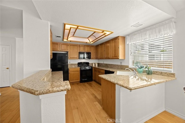 5787 Blackbird Ln, La Verne, CA 91750 - kitchen with black appliances, a peninsula, light wood finished floors, light stone counters, and a textured ceiling