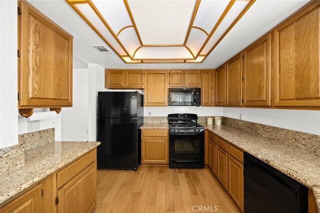 5787 Blackbird Ln, La Verne, CA 91750 - kitchen with black appliances, light wood-style flooring, light stone countertops, and brown cabinetry