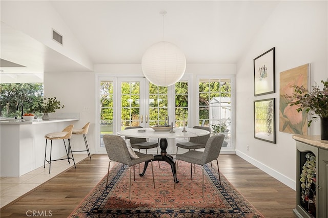 3231 Ruth Elaine Dr, Los Alamitos, CA 90720 - dining area featuring healthy amount of natural light, vaulted ceiling, and wood finished floors