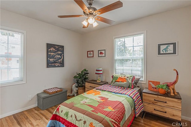7704 Isis Ave, Los Angeles, CA 90045 - bedroom with multiple windows, wood finished floors, baseboards, and ceiling fan