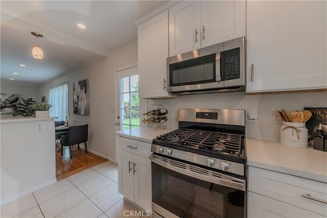 7704 Isis Ave, Los Angeles, CA 90045 - kitchen featuring appliances with stainless steel finishes, light countertops, light tile patterned flooring, white cabinets, and recessed lighting